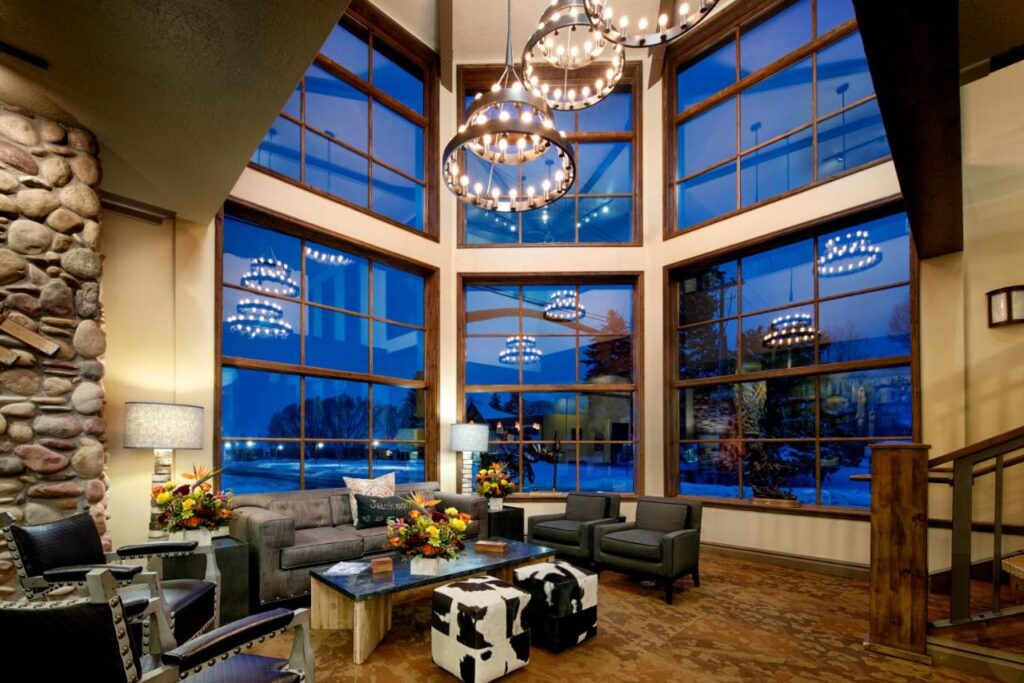 Inside a hotel lobby in Jackson Wyoming with tall glass windows and furniture