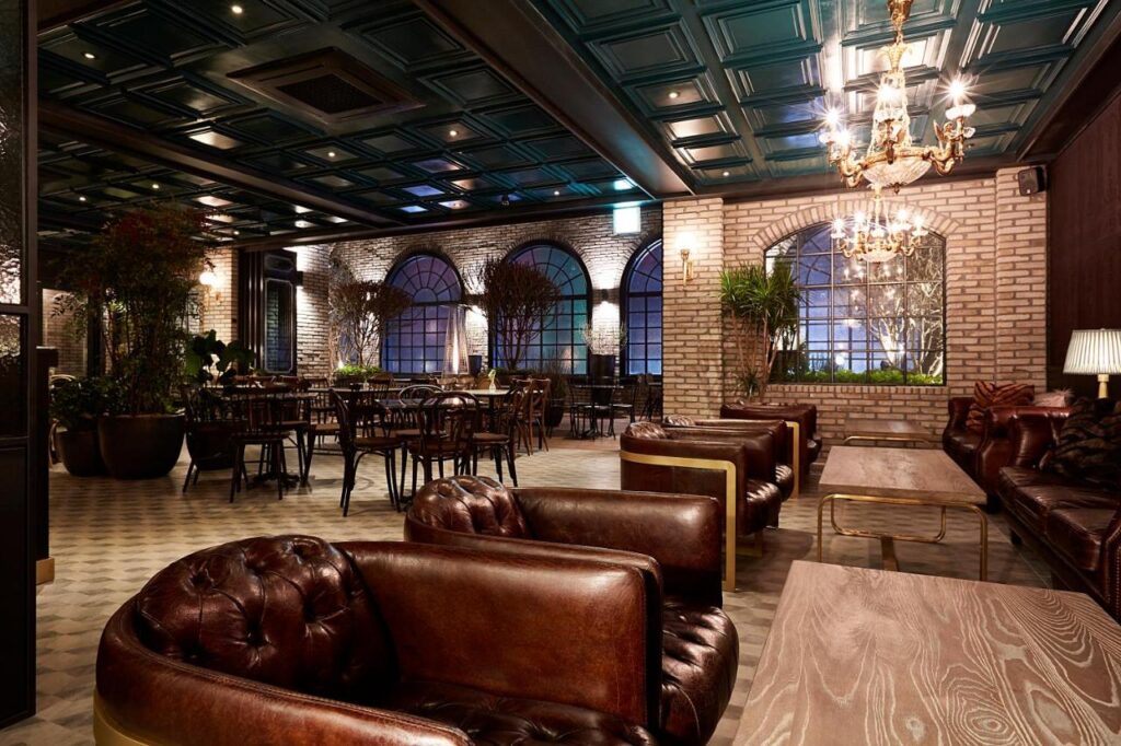 Inside a hotel lobby with leather chairs and brick walls