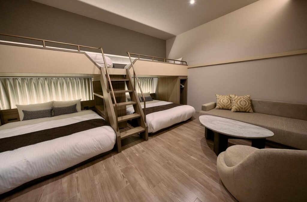 Unique Hiroshima hotel guest bedroom layout with two large beds and a ladder leading to more beds above