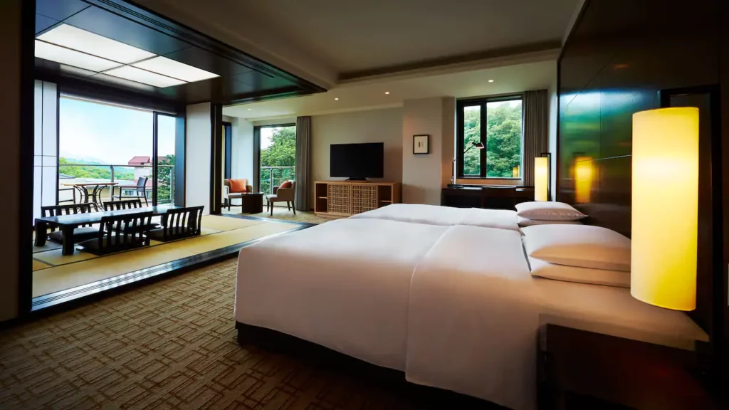 Inside an upscale guest bedroom with bed leading to authentic Japanese tatami floor and a balcony