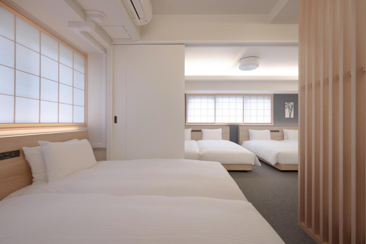 Inside a large guest room at a hotel in Shinjuku with four beds and Japanese style windows