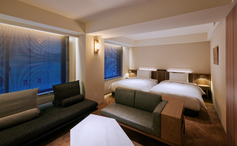 Inside a Tokyo hotel guest bedroom with beds and sofas