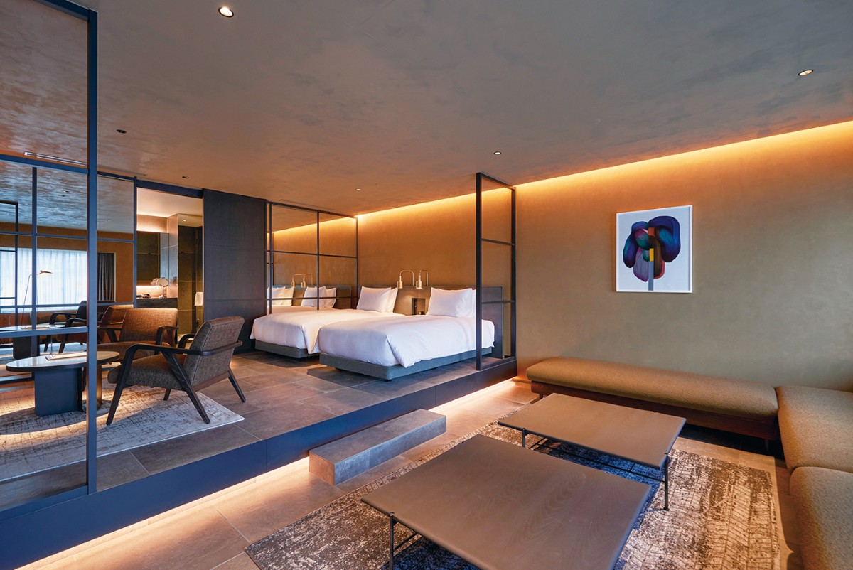 Inside a plush guest room at a Kyoto hotel with beds and seating areas
