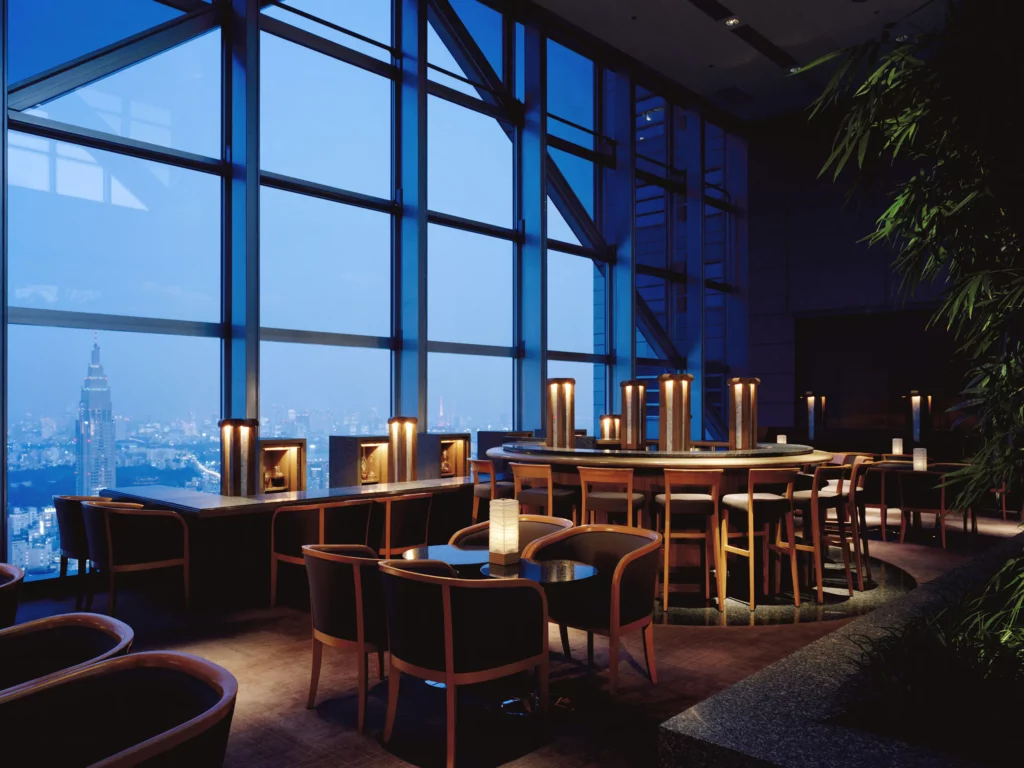 Photo of a 5 star Tokyo hotel bar with luxurious seating and large glass windows with a view