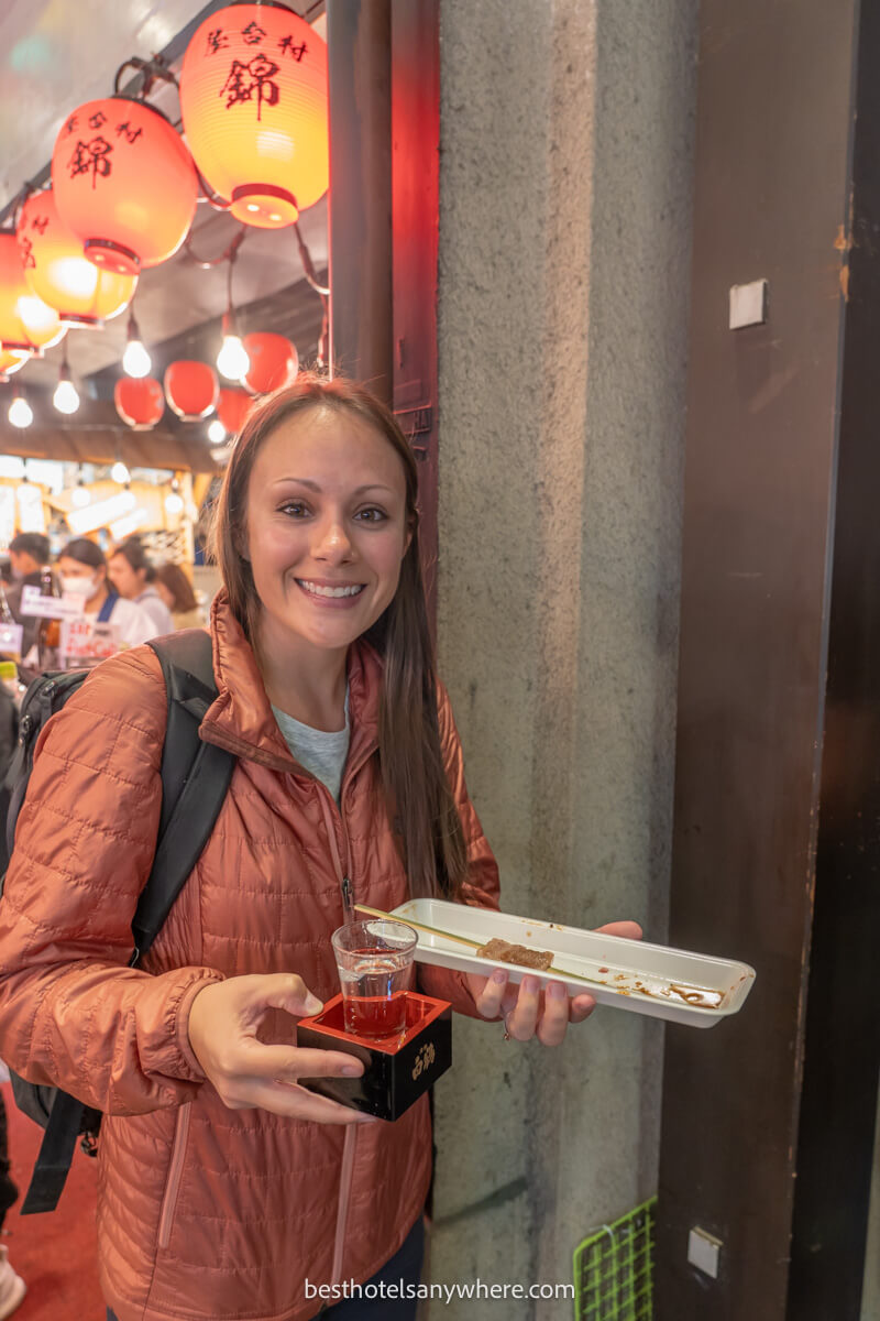 Tourist eating kobe beef and drinking sake in Nishiki Market in Kyoto