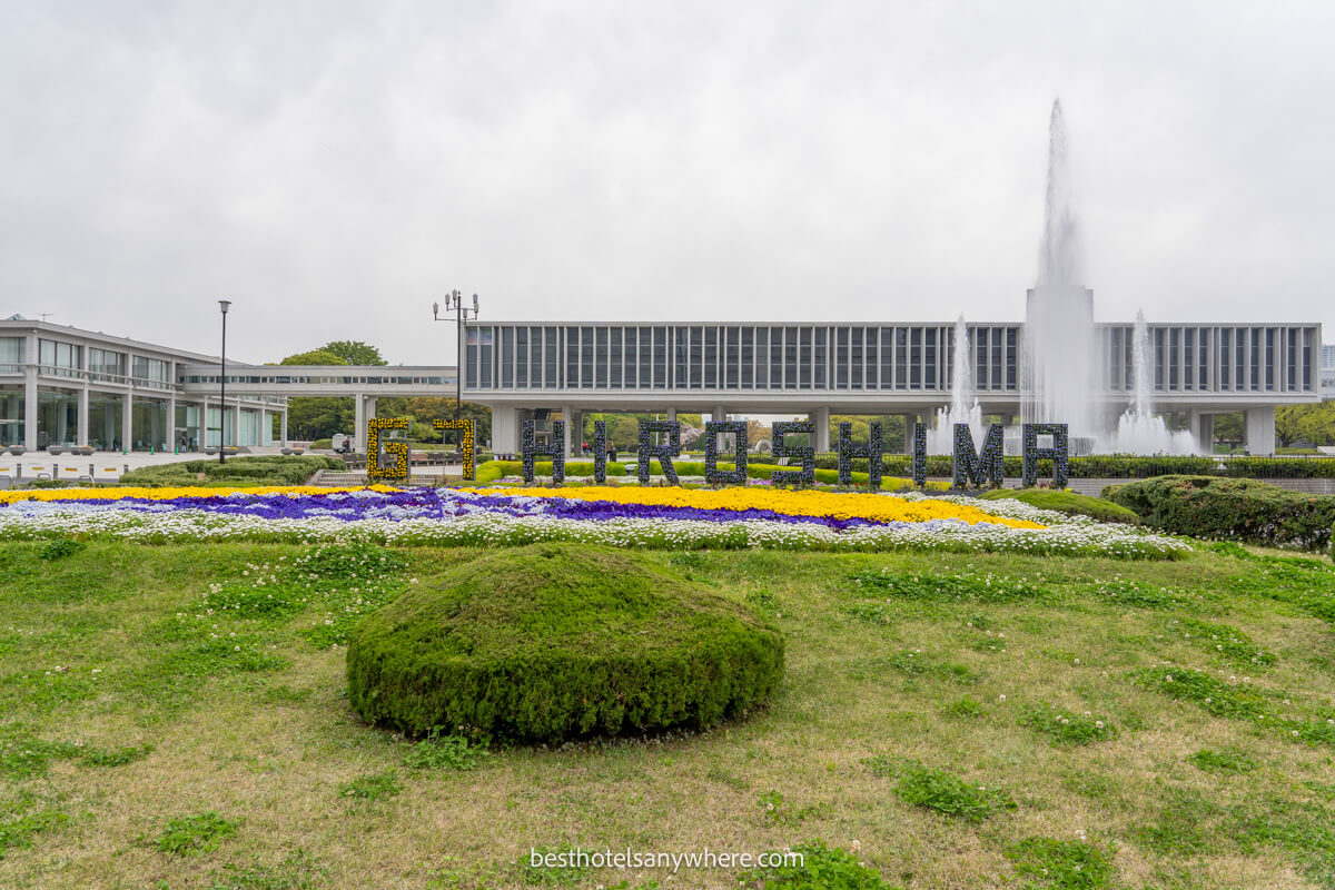 Hiroshima Peace Memorial Park grounds with museum and fountain behind flowers