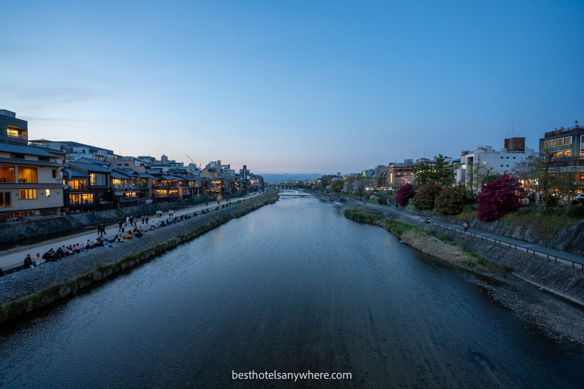 Looking down the Kamo River from a bridge at dusk