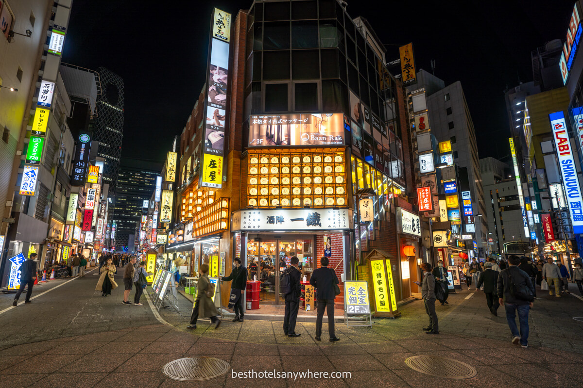 Wide angle photo showing streets lit up at night in Shinjuku with restaurants lining the roadsides