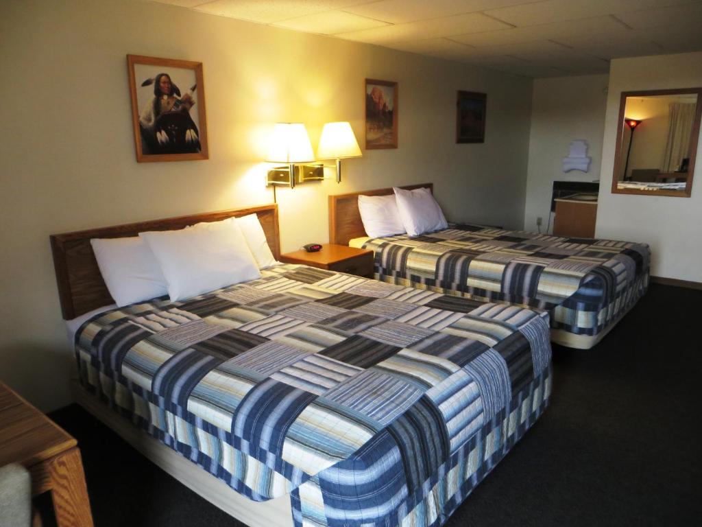 Inside a guest bedroom with two beds and patterned duvets at a hotel in Custer SD