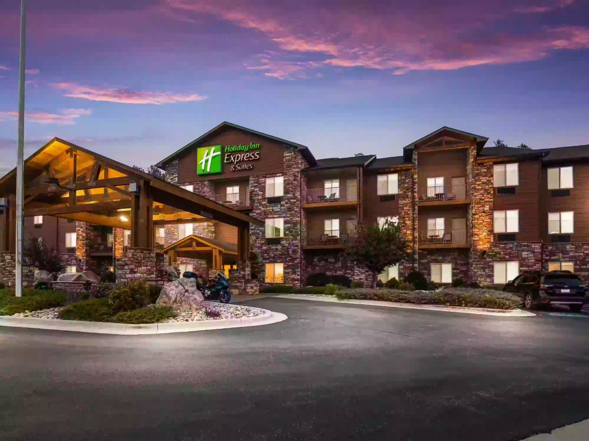 Exterior photo of a Holiday Inn hotel in Custer SD at dusk with colors in the sky