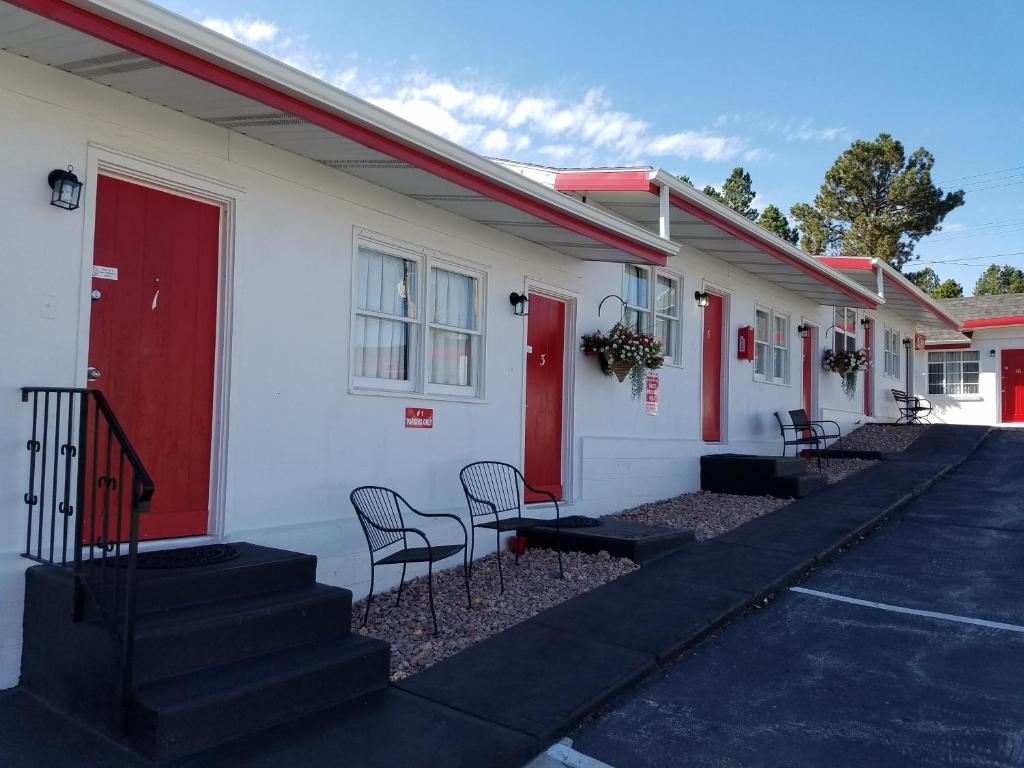 Exterior photo of a row of motel rooms in Custer SD with a blue sky behind