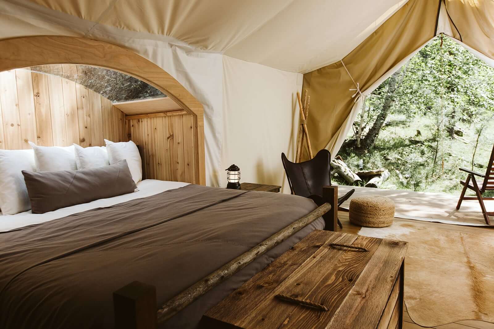 Inside a luxury glamping tent with bed and seating areas