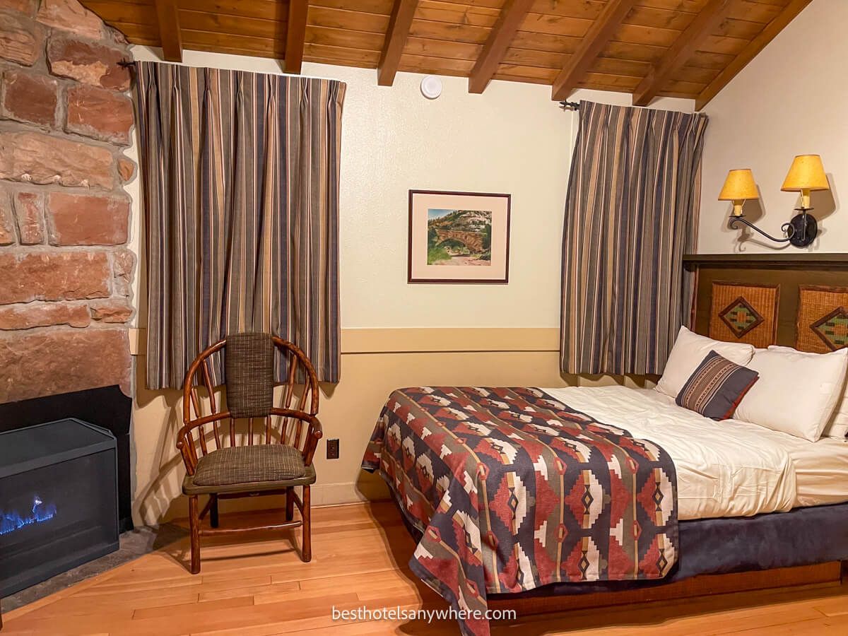 Inside a western cabin at Zion Lodge with bed and fireplace