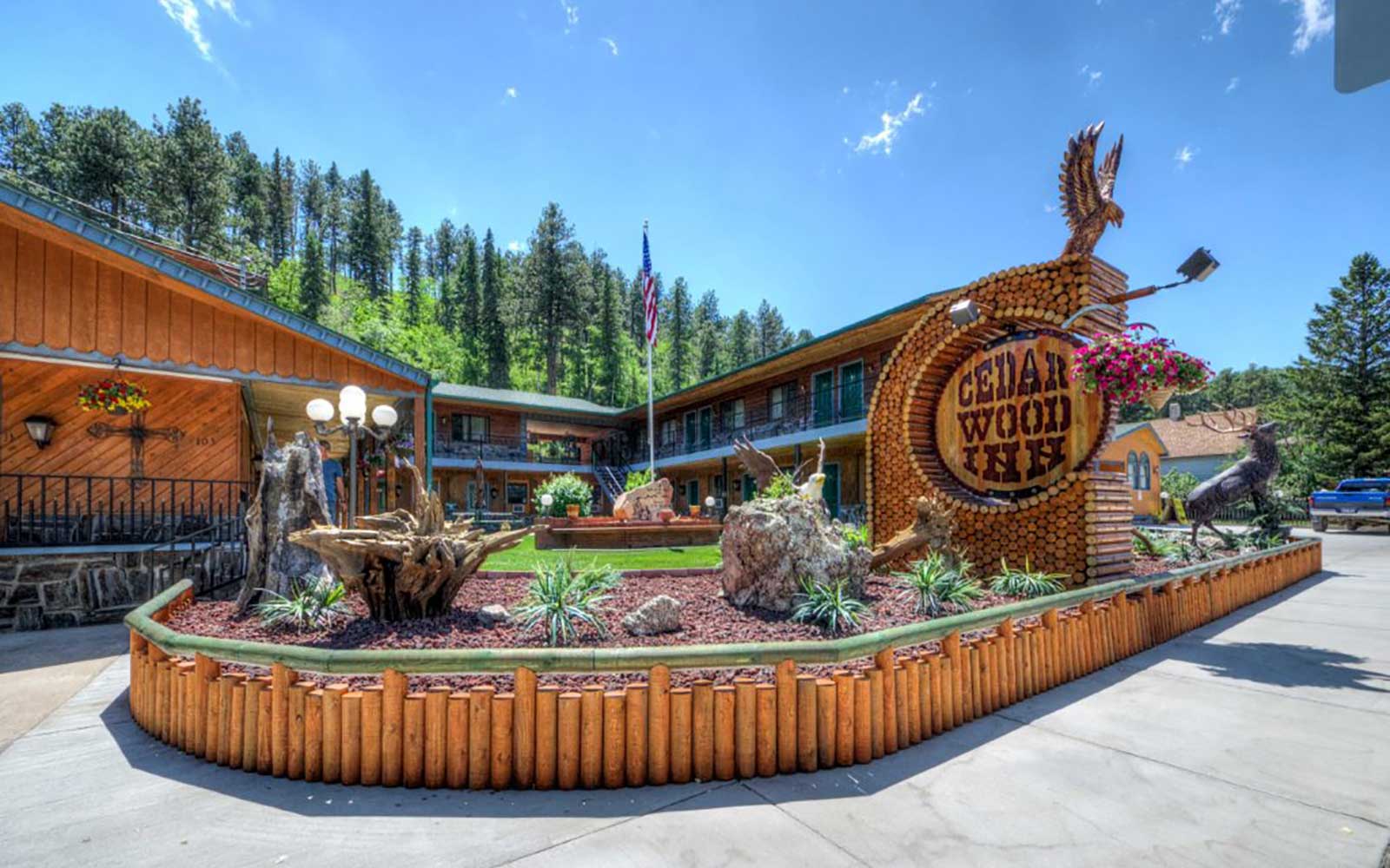 Exterior photo of a hotel in Deadwood South Dakota with wooden buildings and entrance sign