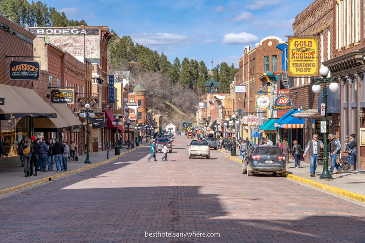 Photo of historic Deadwood SD shops, bars, saloons and restaurants on a sunny day with shadows on the road