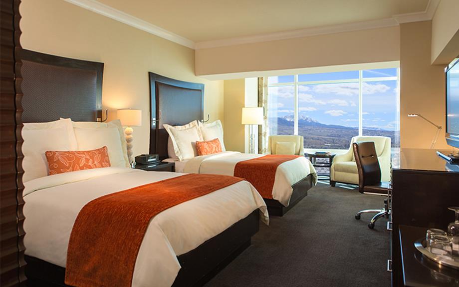Guest room at Atlantis Resort in Reno with two queen beds and orange throws