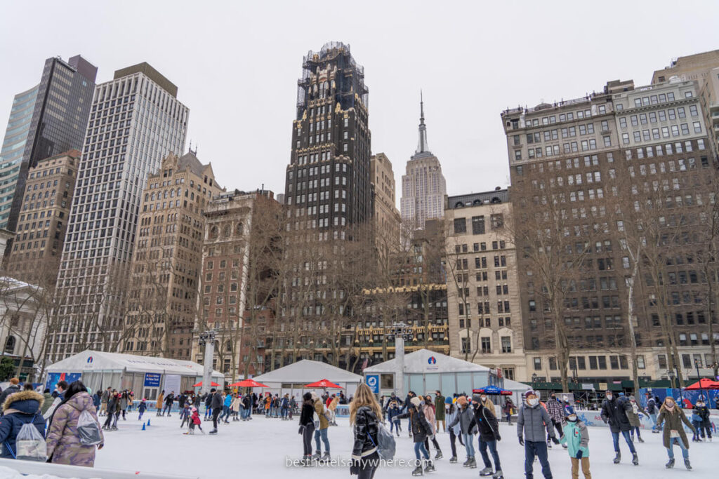 Bryant Park ice skating rink in winter with buildings towering up behind