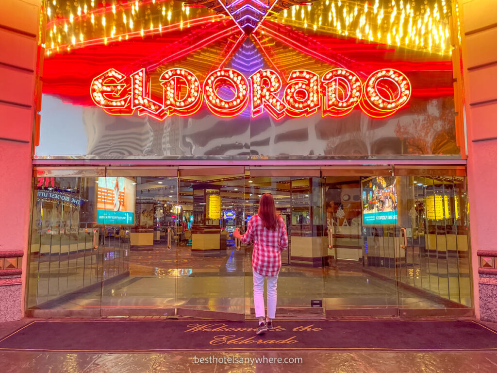 Person walking through a glass doorway entrance with Eldorado letters above lit up