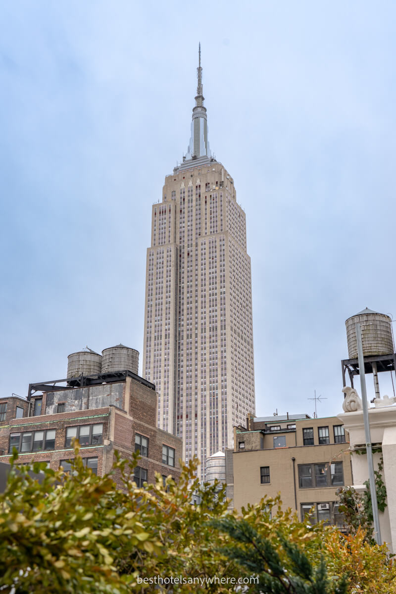 The Empire State Building bursting high into the NYC skyline from a rooftop bar