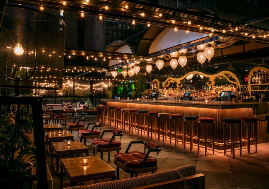 Plush bar lit up at night with tables and chairs empty