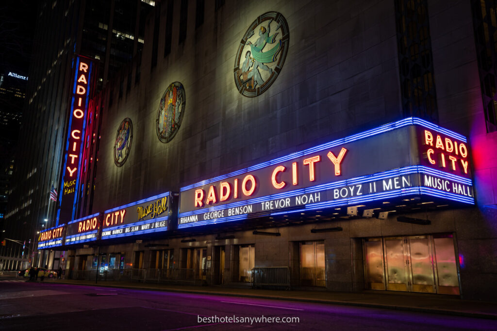 Radio City NYC exterior photo at night with purple and pink neon lights