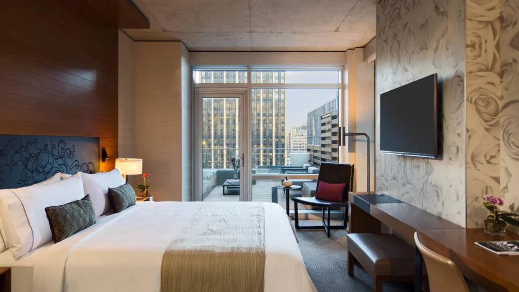 Guest room at Renaissance Midtown hotel in NYC with bedroom leading out to terrace and views