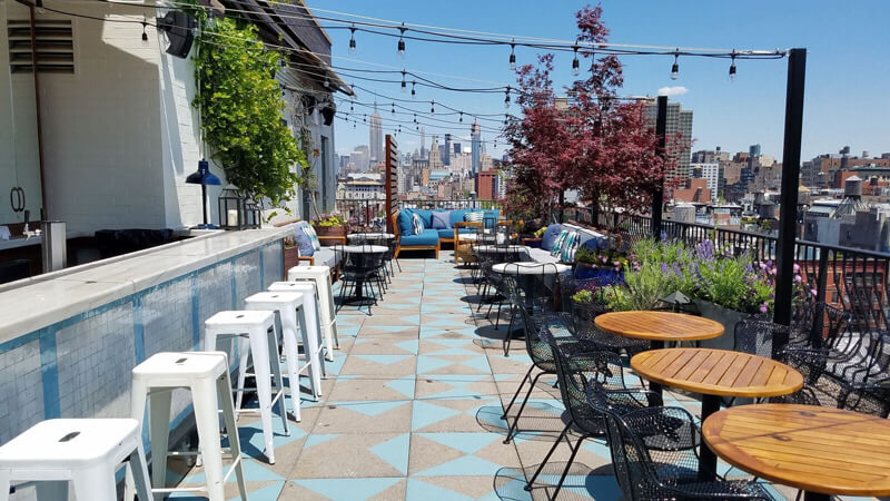 Rooftop terrace with tables and chairs at SIXTY SoHo hotel in NYC