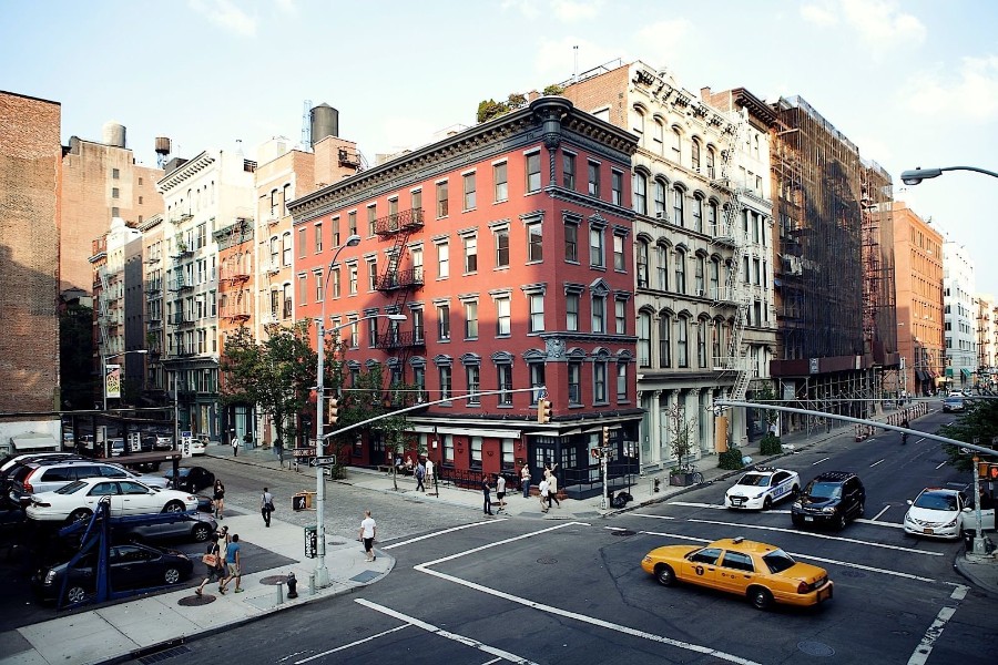 Exterior photo of The Broome Hotel in SoHo New York City with traffic and pedestrians on a sunny day