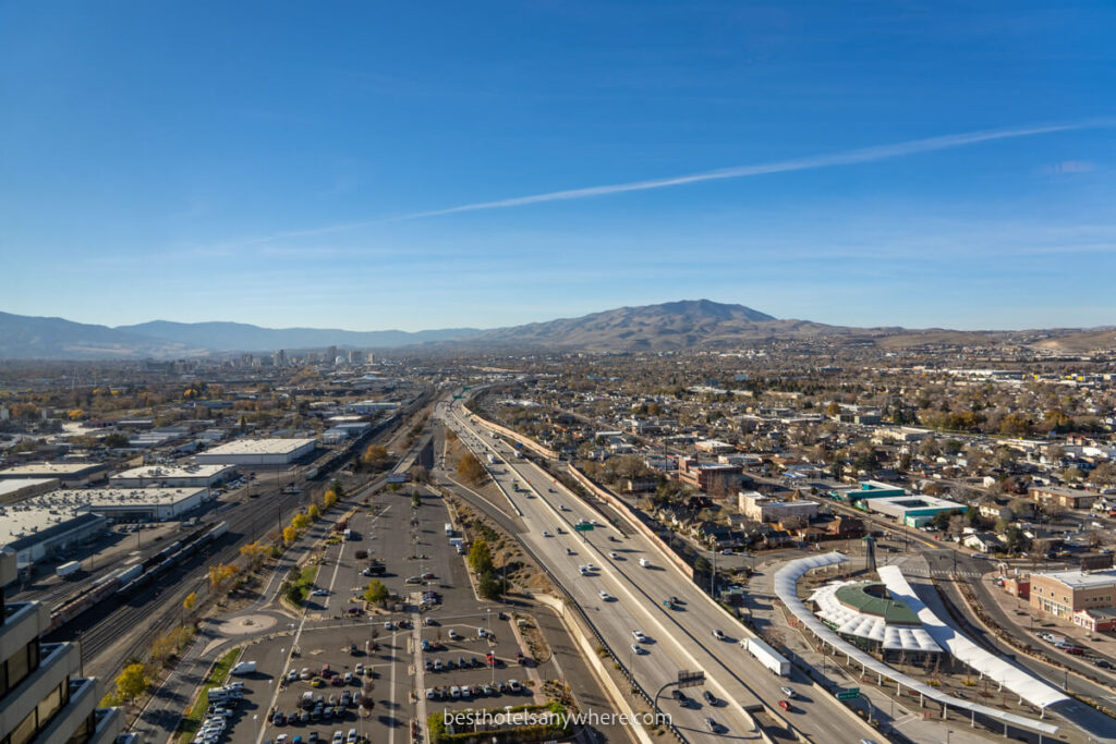 Elevated view over roads and downtown Reno with mountains in the distance on a sunny day with blue sky
