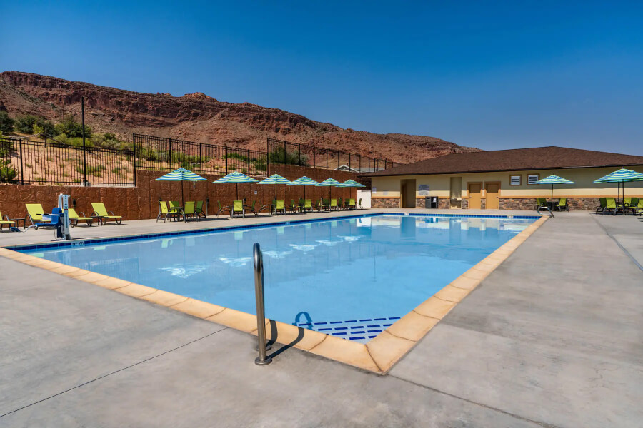 Swimming pool with views over red rocks in background and deep blue sky in Utah