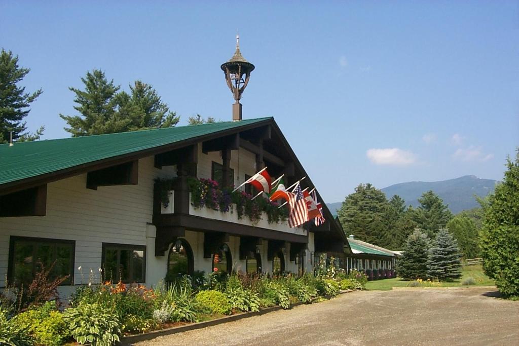 Exterior photo of an Alpine themed lodge on a sunny day surrounded by trees