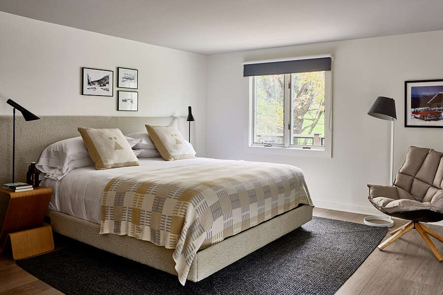 Guest bedroom with double bed and chair in a bright and smart room