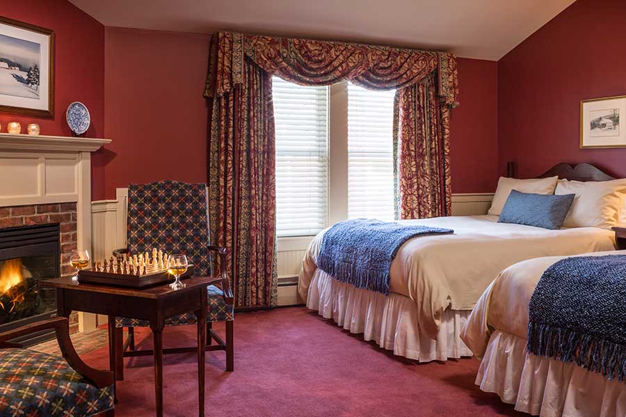 Guest bedroom decorated in old word charm with fire place and chess set