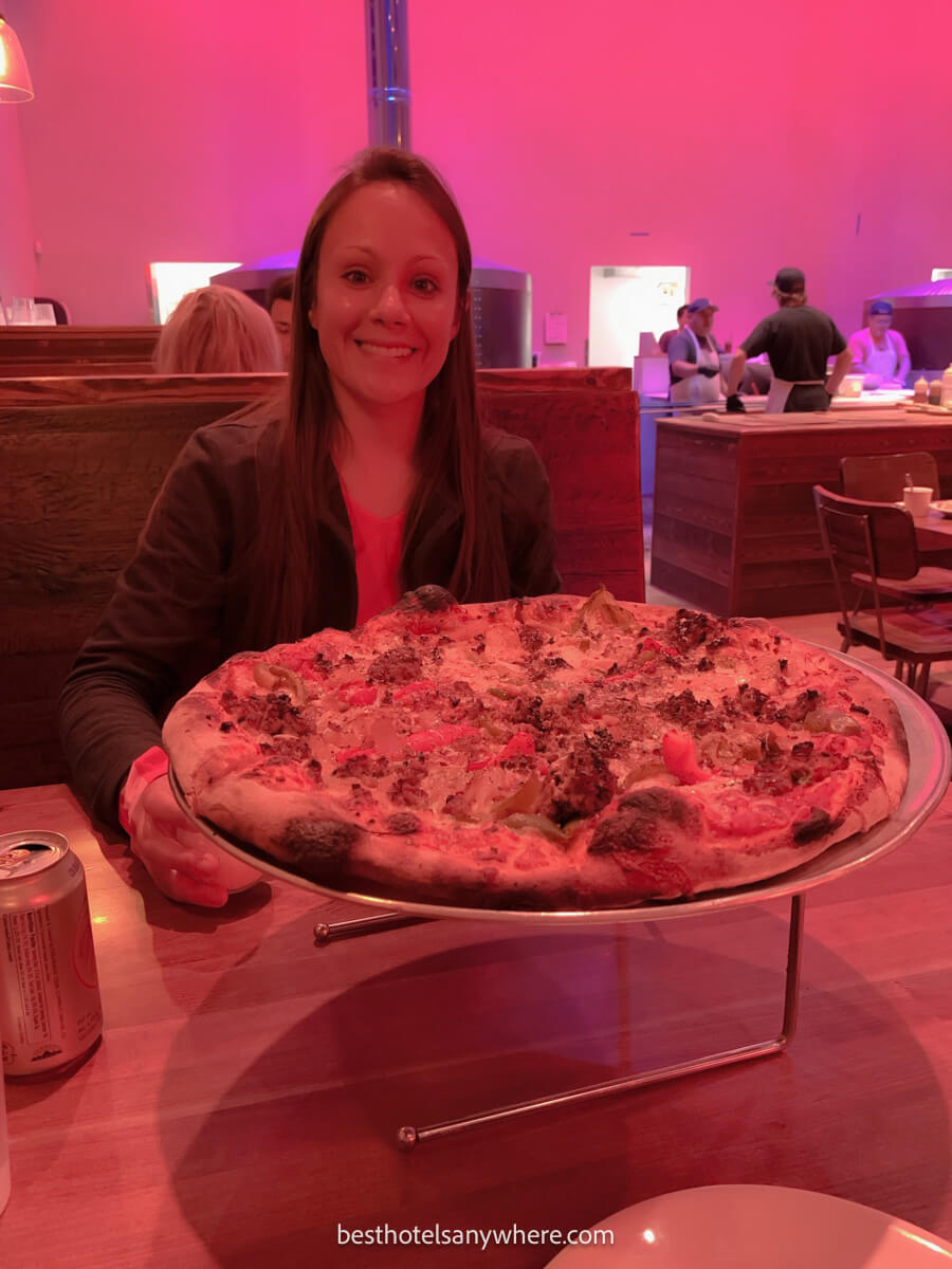 Tourist in Jackson Wyoming eating a pizza in a restaurant with bright pink lights